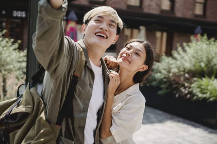 Girl clings on the guy while taking photo