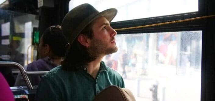 Man on a bus staring outside the window.