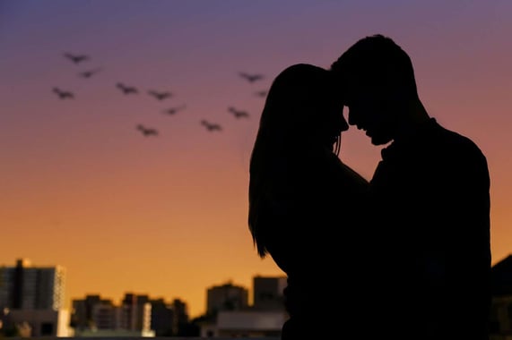 A couple with a soul bond connection silhouetted against a skyline background.