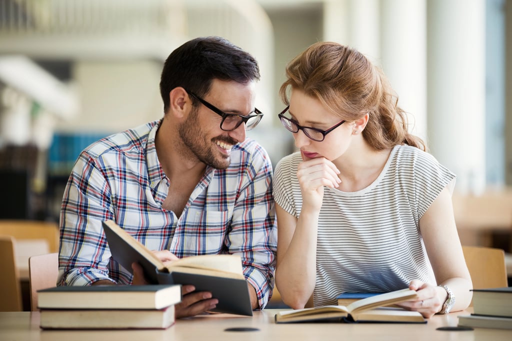 A couple in library having discussion about book.