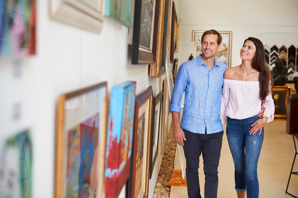 A couple looking at paintings in art gallery.