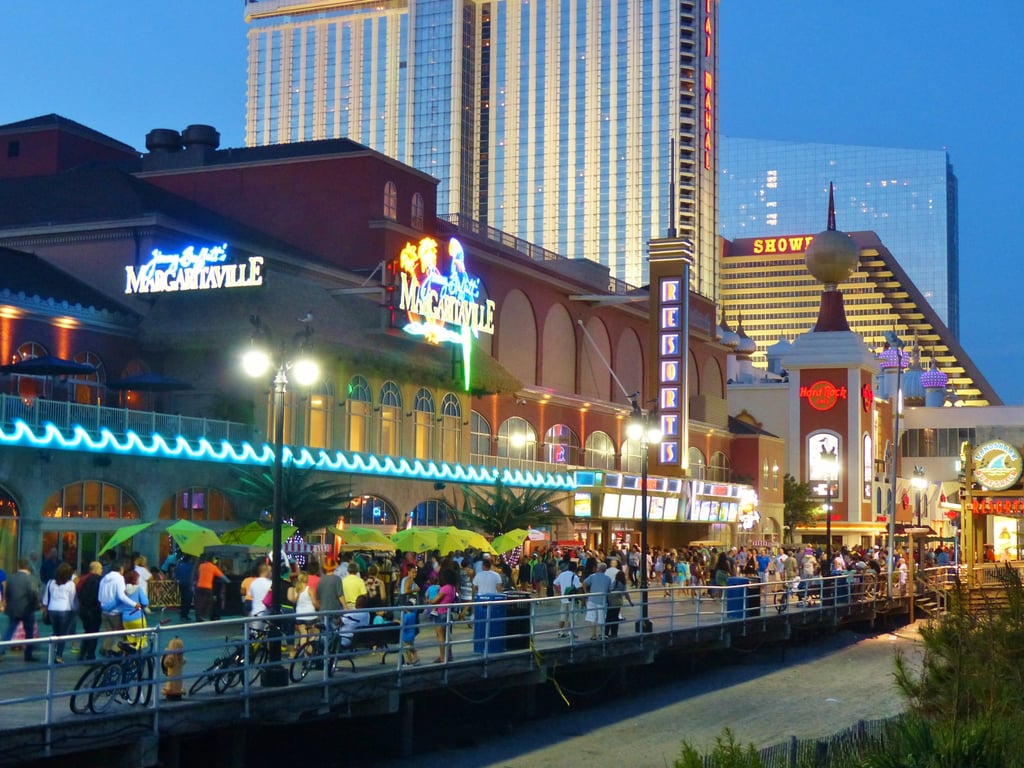 Atlantic City Boardwalk at night, lit by neon signs.