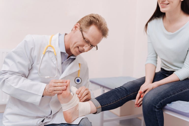 Doctor applying a compression bandage to a patient’s lower leg during clinical treatment