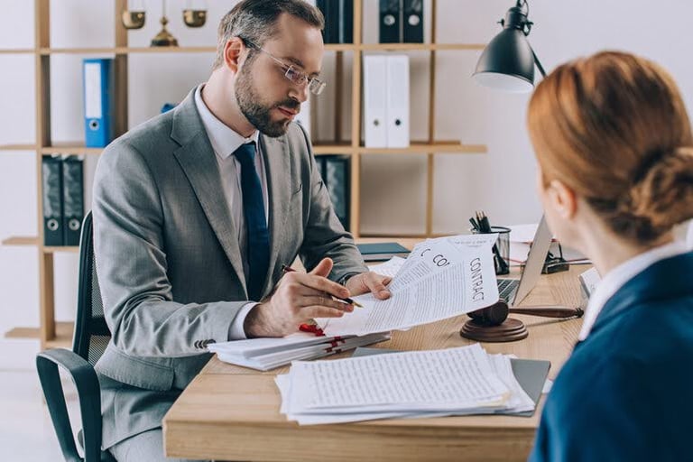 Criminal defence lawyer reviewing legal documents with a client in an office