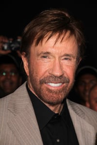 Portrait of Chuck Norris in black shirt and gray suit jacket