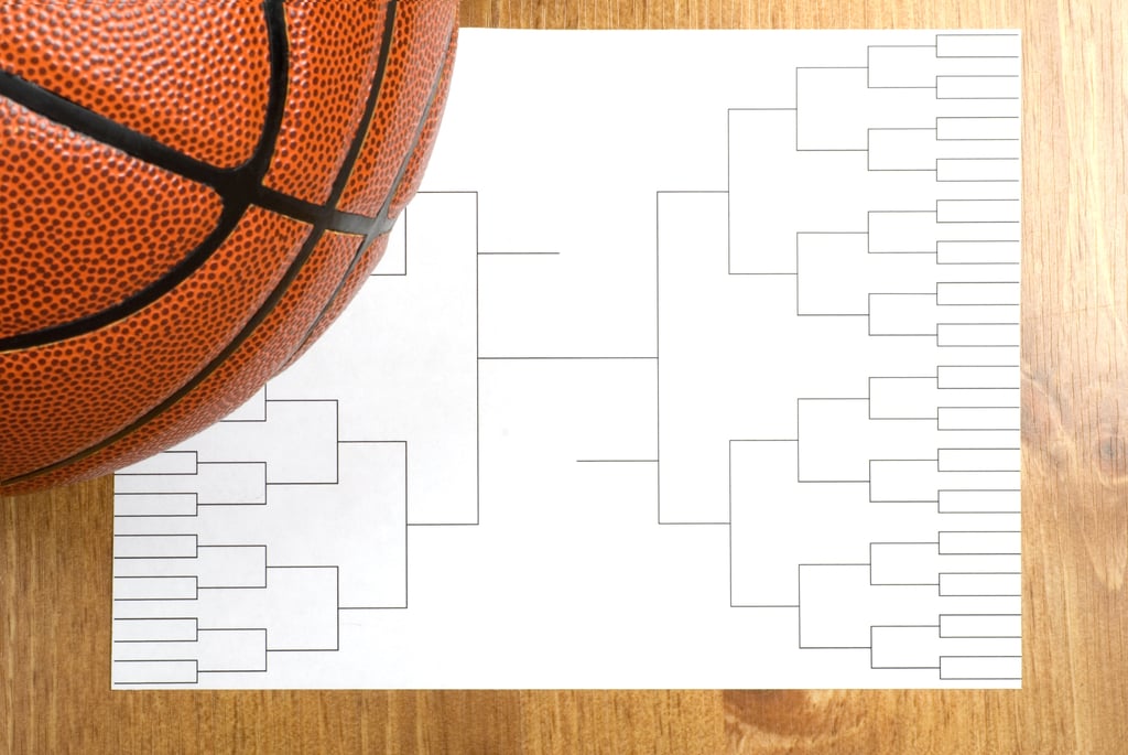 First-week March Madness basketball bracket with basketball sitting atop it.