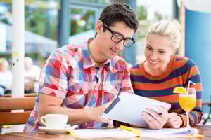 Couple sitting at office table discussing shared expenses and budgeting together in a relationship planning conversation