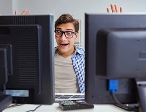 Man excitedly reacting to multiple computer screens while searching for safe social casino sites and avoiding clone website traps.