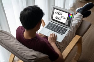 A man using a MacBook casually at home, browsing and working online.