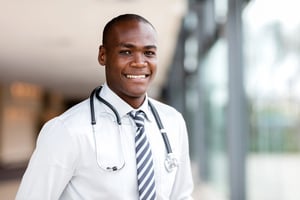 Smiling doctor with a stethoscope in a hospital, representing career growth through an international medical internship.