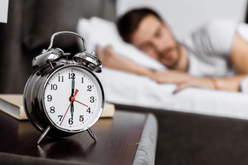 Man sleeping next to alarm clock