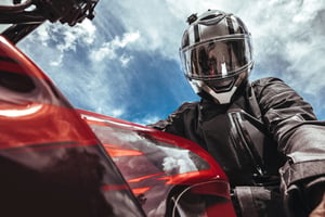 Man riding a motorcycle on an open road, representing rider safety and awareness of legal rights after a traffic accident.