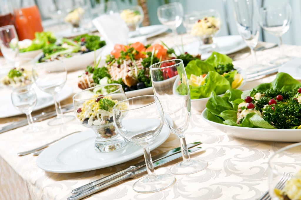 Dinner table set with salads and empty glasses