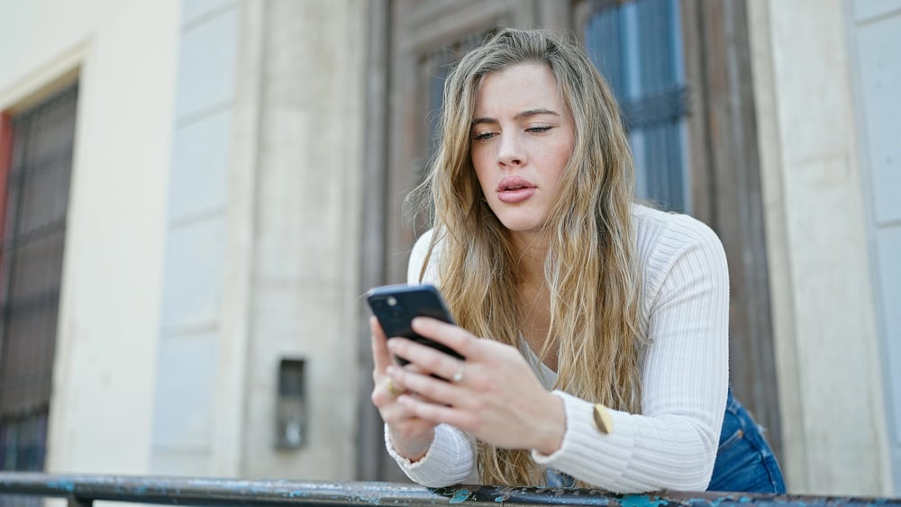 A woman looking at her phone while texting someone