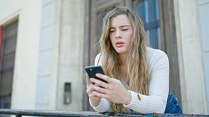A woman looking at her phone while texting someone