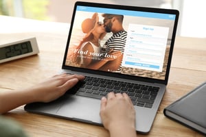 Hands on a laptop to create an account on a dating site.
