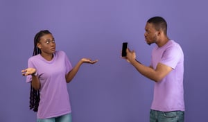 Man showing his phone to a confused woman during an unclear situationship conversation