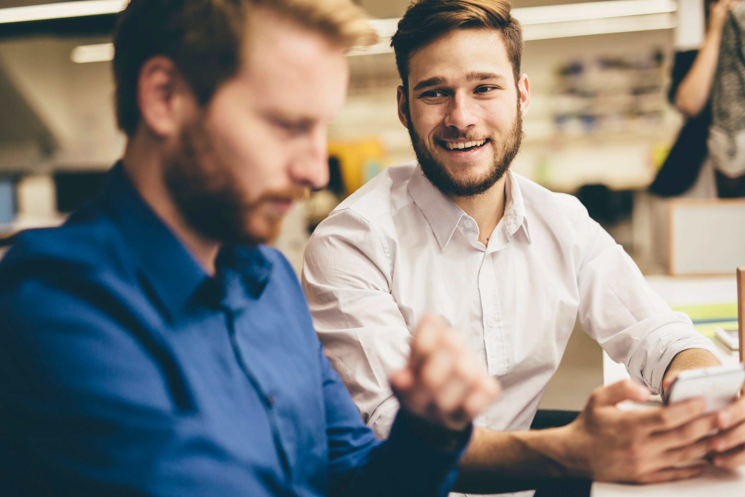 Two men sitting dressed in business casual outfits