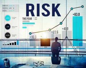A professional analyzing rising risk and performance charts on a large screen, reflecting disciplined decision-making under pressure in trading.