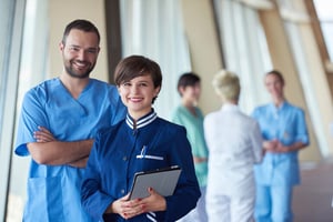Two workers standing in their professional dress codes, illustrating healthcare staff and career roles in the growing healthcare industry.