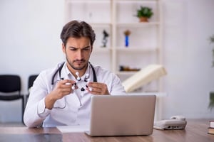 A focused doctor analyzing a molecular model while working on a laptop, illustrating the shift toward data-driven online healthcare.