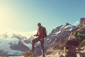 Hiker standing on a mountain peak, symbolizing risk-taking and adventure.