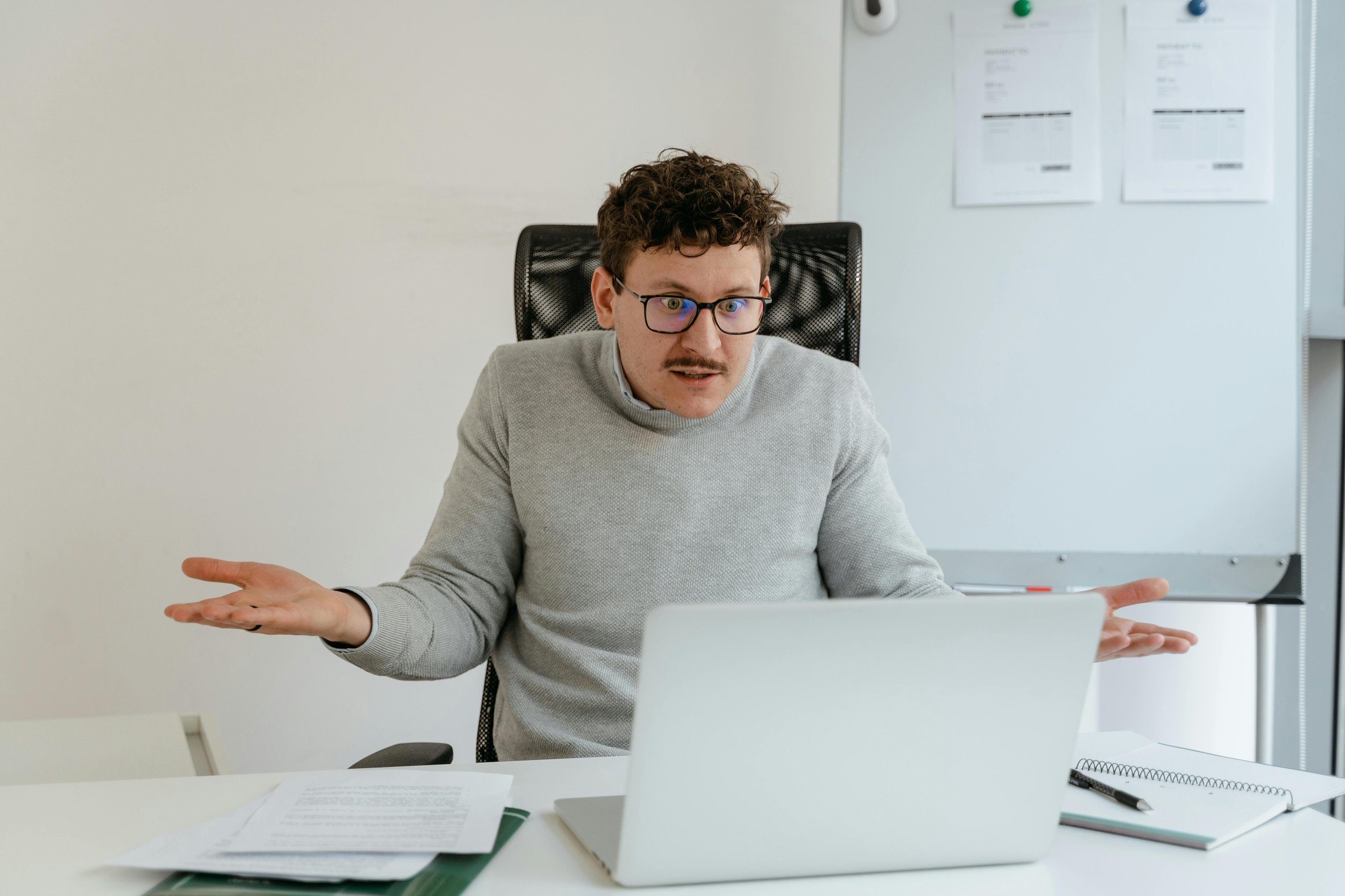 Man looking at laptop shrugging